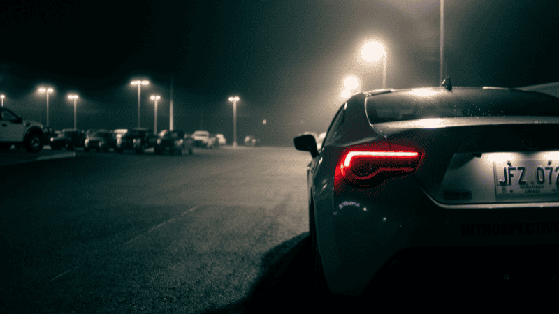 A car with working sidelights on a road. 