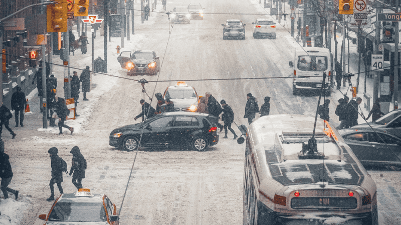 There are cars and pedestrians on the road
