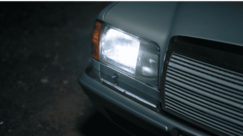 The headlights of a very retro vehicle were turned on, emitting white light