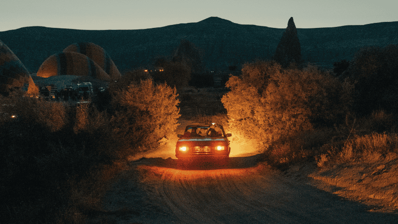 A car driving on a deserted land road.