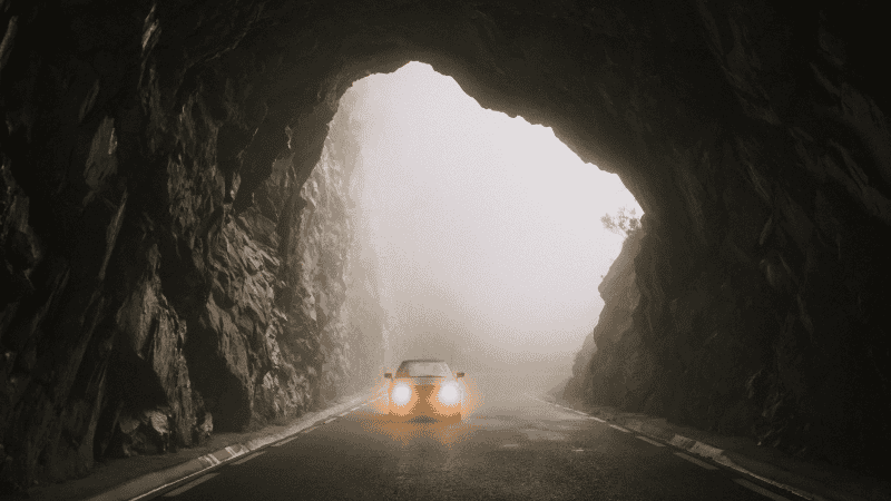 Car Entering a Tunnel with Headlights On