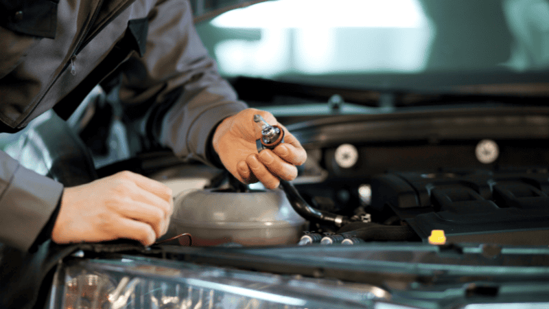 The man is replacing car bulbs 