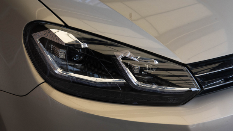 The picture is a close-up shot of the car's headlights without any other elements. The details of the headlights are clearly visible, including the lampshades, lamp groups, and internal lighting components. The focus of the picture is concentrated on the front of the car.